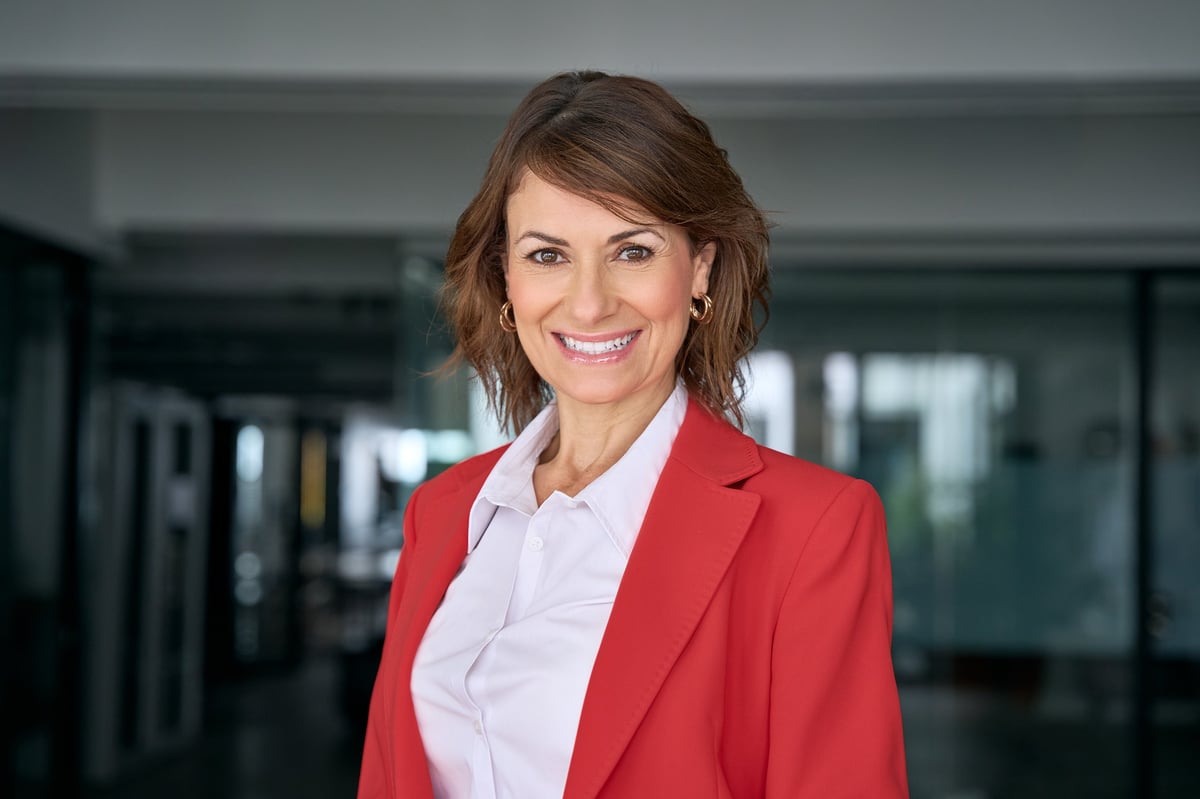 Headshot close up portrait of latin hispanic confident mature good looking middle age leader, ceo female businesswoman on blur office background. Gorgeous beautiful business woman smiling at camera.
